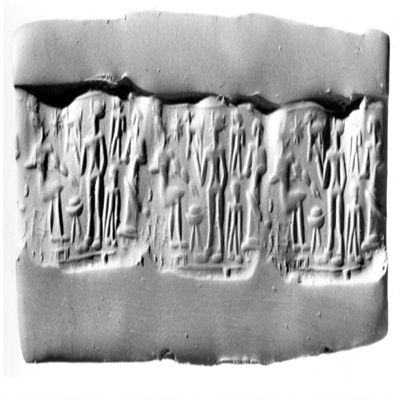 Cylinder seal. Seated figure with feet on raised podium, offering table, nude worshipper with one raised hand, two small figures, figure in long dress, single line border above and below. 2nd mill. Hematite.; YPM BC 029869