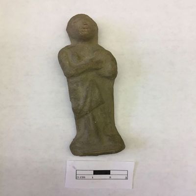 Figurine, double mold. Standing female musician holding tamburine or drum at left shoulder, wearing long robe, braided headband. Selucid, Parthian. Clay.; YPM BC 016851