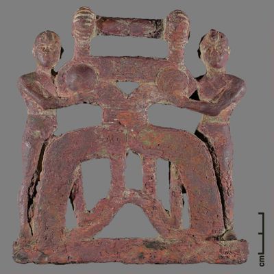Openwork plaque. Openwork bronze plaque showing two kilted males supporting an architectural(?) element. Old Babylonian?. Bronze.; YPM BC 016783
