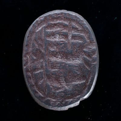 Amulet. Ob: Roughly drawn choubis in ouroborus? Rev:looo/rostin/roend/armatid/oyioy ('...son of Armatides'). Black stone.; YPM BC 038612