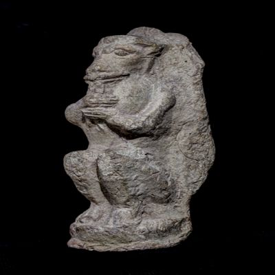 Figurine, single-mold; squating monkey playing double flute, feet on pedestal; YPM BC 016854