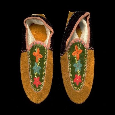 <bdi class="metadata-value">Moccasins, dark brown moose hide, tongue decorated with blue, green and red embroidery on green velvet background; shoe is trimmed with black velvet and pink cotton drill, made by Mrs Joe George at Lower Post, BC, Kaska, N Athapaskan; YPM ANT 058351</bdi>