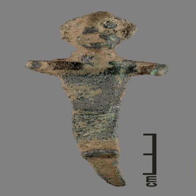 Figurine. Anthropomorphic figure with conical hat curved backwards, arms spread, joined feet, hatchings on lower body, peg like ending under feet curved barckwards. Bronze.; YPM BC 031128