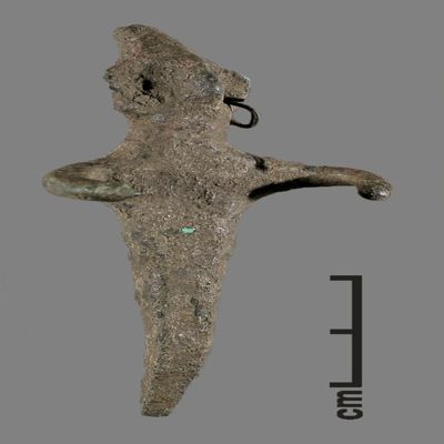 Figurine. Anthropomorphic figure with small conical hat, one earring, arms spread, lower body ending like a peg. Bronze.; YPM BC 031119