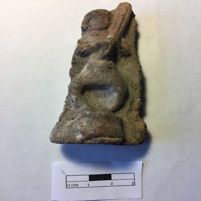 Figurine, double mold. Male musician holding harp over right shoulder, bowlegged, standing on circular platform, wearing loincloth, thickly curled hair; some reddish wash remaining. Selucid, Parthian. Clay.; YPM BC 016843