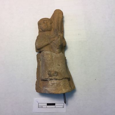 Figurine, double mold. Female musician, seated, holding harp over left shoulder, on left knee, playing with both hands, feet resting on platform, wearing long garment. Selucid, Parthian. Clay.; YPM BC 016849