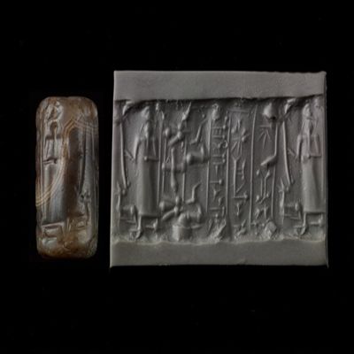 Cylinder seal. Figure holding rod, 3 antelopes/goats, cross, 2 flies; 3-line inscription. Kassite. Gray/brown agate.; YPM BC 013940