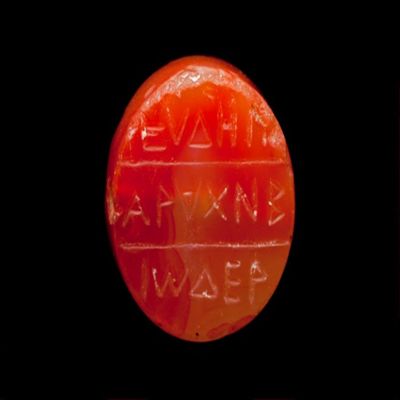 Amulet. Ob: eyde-i/arachnb/io-der ( text lost when cut down in size). Rev: blank. Pinkish orange stone.; YPM BC 038621