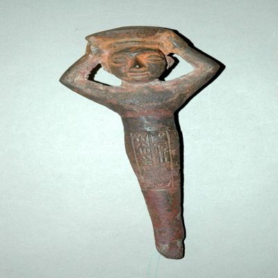 Foundation figurine, solid cast. Female bearing basket on her head, lower part of body tapering to slender point. Inscription on lower waist and legs. Ur-Ningirsu peg, for Ninmarki. Post Sargonic. Copper.; YPM BC 016871