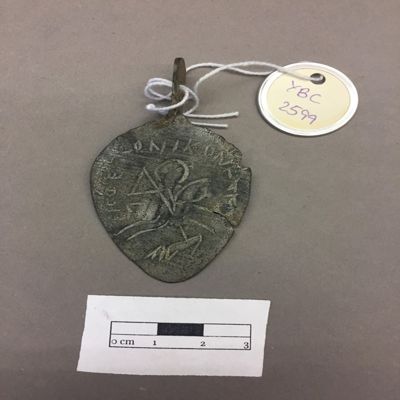 Amulet. Leaf-shaped pendant, Greek letters ('one god who conquers evil') encircling horse rider spearing an animal, inscription on back. Byzantine. Bronze.; YPM BC 017050