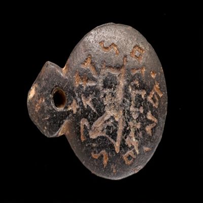 Amulet. Ob. Ibis tied to altar/effaced Greek letters below Corisrio/oai? Rev: Four Egyptian gods on uterus and key (circle with tab for suspension). Black stone.; YPM BC 038601