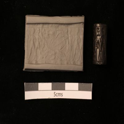 Cylinder seal. Bird, two prone humans, two kilted figures in equid-drawn chariot, two marching figures in kilts, linear borders. Mitannian. Hematite.; YPM BC 037240