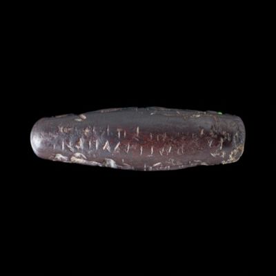 Amulet. Anubis, Horus on lotus, mummiform Osiris and female goddess (Isis?); five rows of very small text (spindle). Hematite.; YPM BC 038619